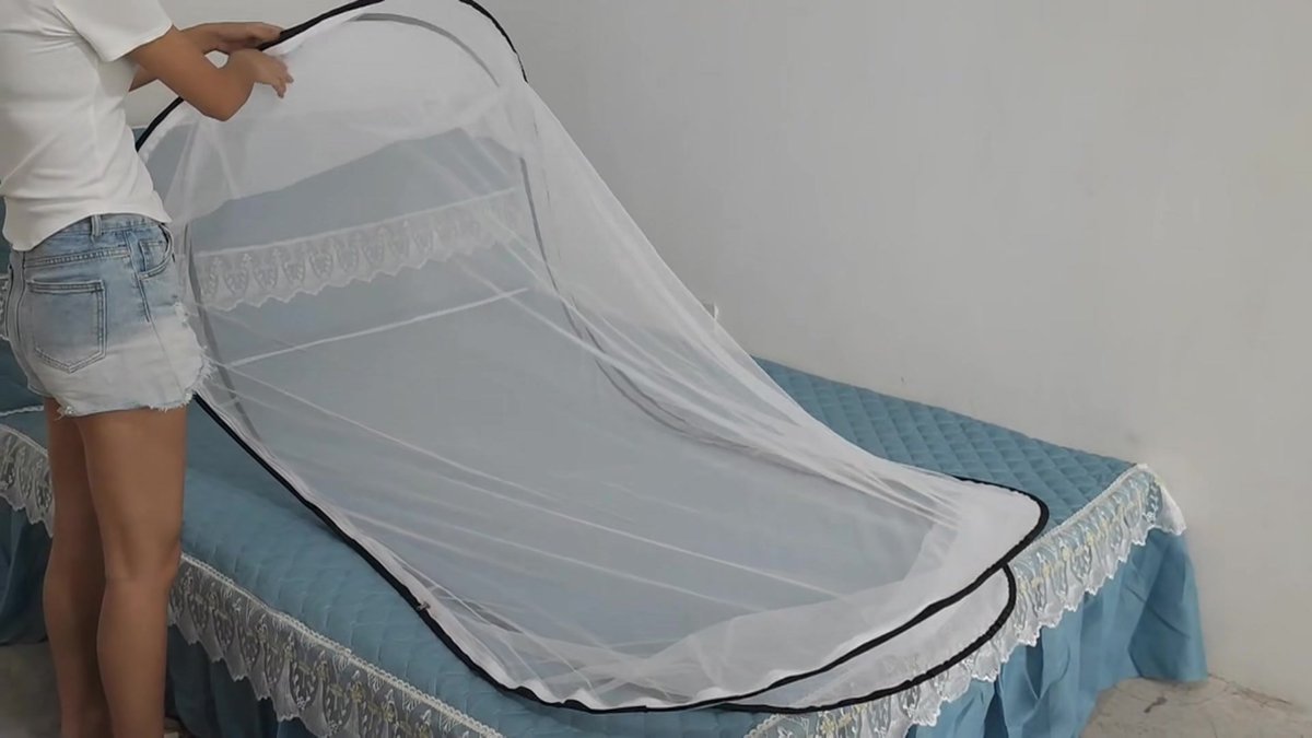 Pop-up mosquito net opened over a single mattress